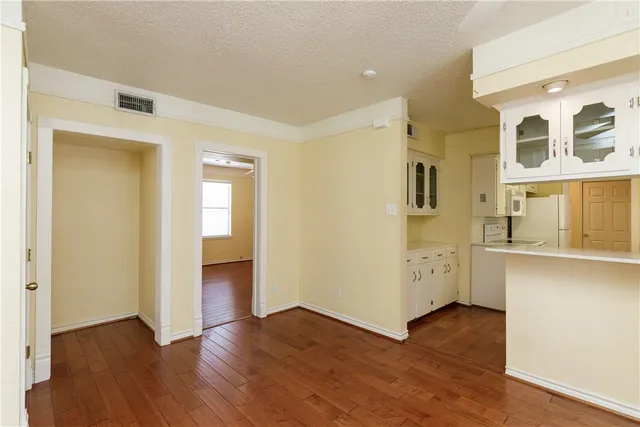 a view of a hallway with wooden floor and closet