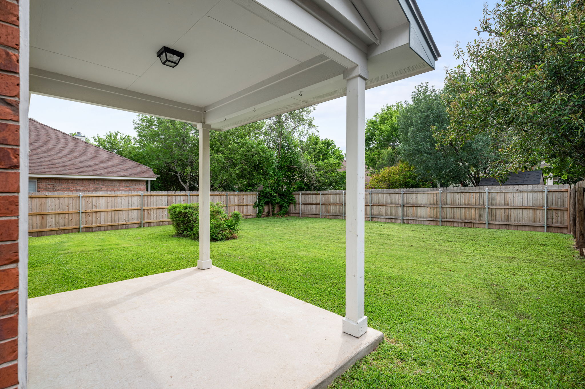 10004 Isle Royale Way Austin, TX 78747 - Photo 26 of 31 A spacious, verdant yard provides ample room for recreation and relaxation under a covered patio.