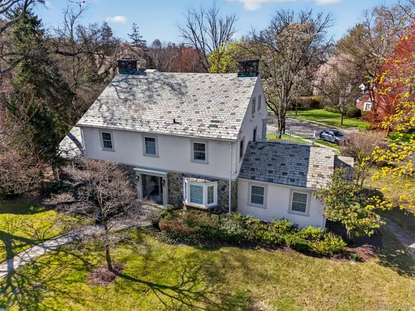 a aerial view of a house with a yard and large tree
