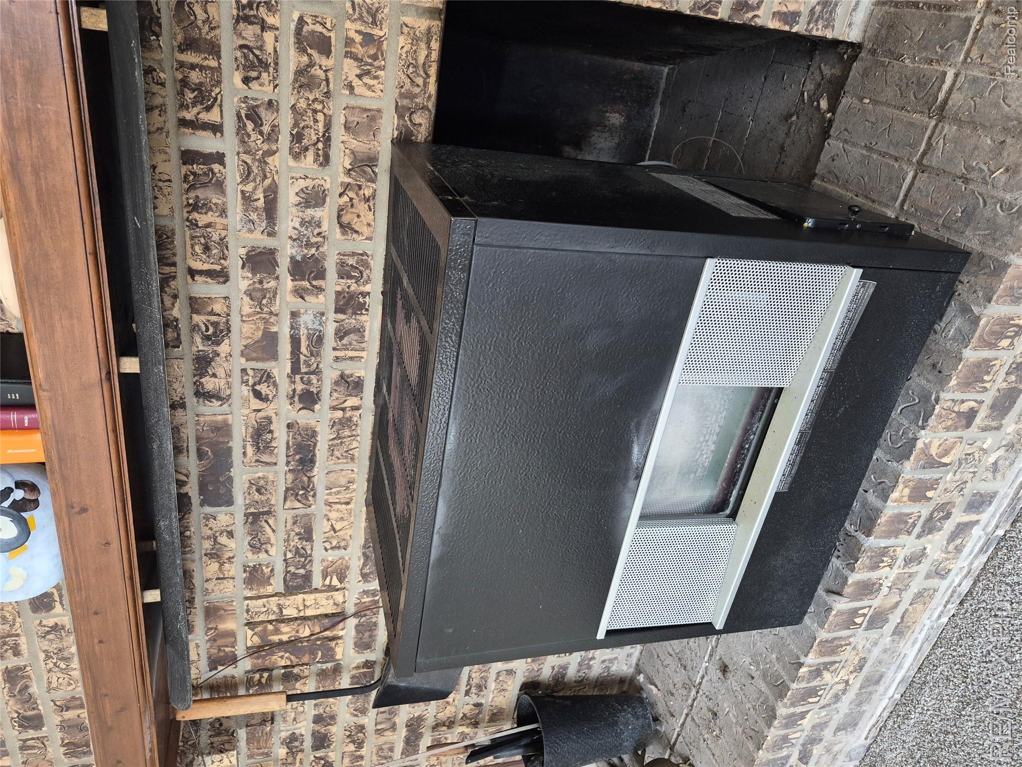 1115 Turrill Road Lapeer, MI 48446 - Photo 6 of 50 Detailed view of brick wall, a wood stove, and heating unit