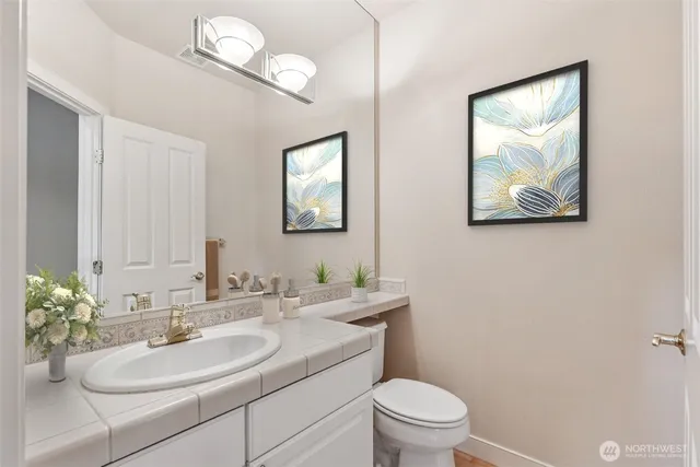 a bathroom with a toilet a sink and mirror