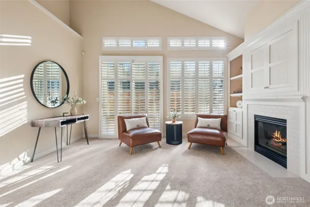 a living room with furniture a fireplace a large window and a large window
