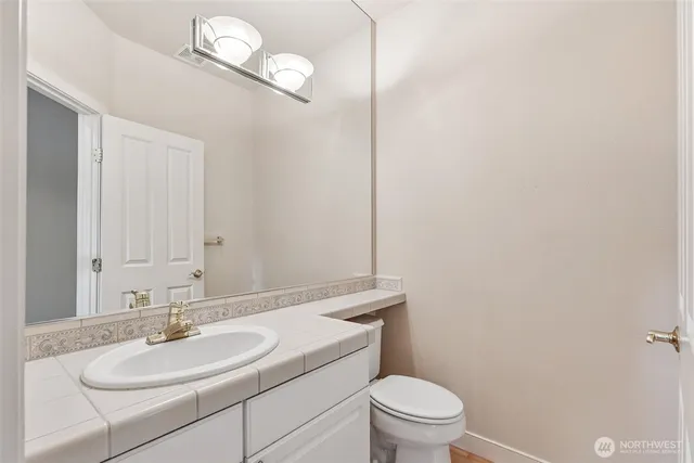 a bathroom with a sink a toilet and a mirror