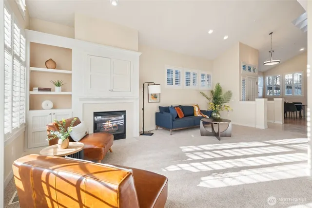 a living room with furniture a fireplace and a dining table with wooden floor