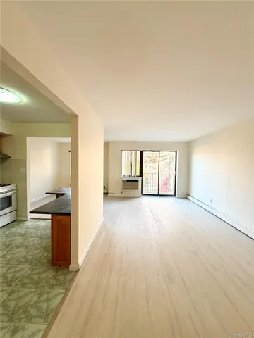 a view of a room with wooden floor and a window