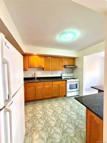 a large kitchen with granite countertop a sink and a stove