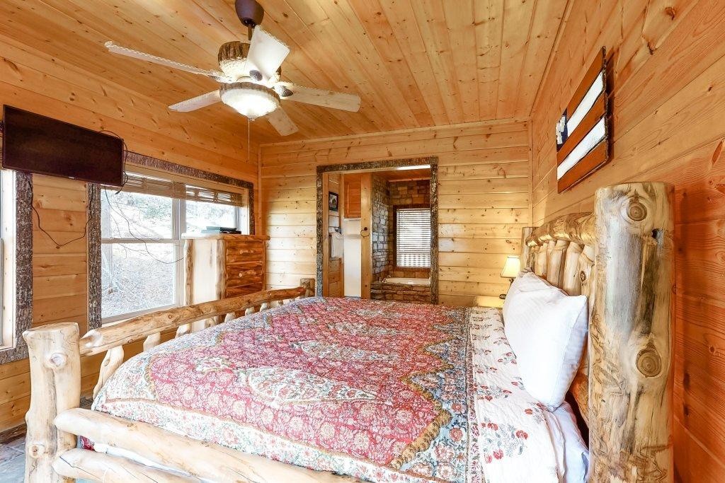 2556 Treehouse Lane Sevierville, TN 37876 - Photo 11 of 24 a spacious bedroom with a large bed and a chandelier