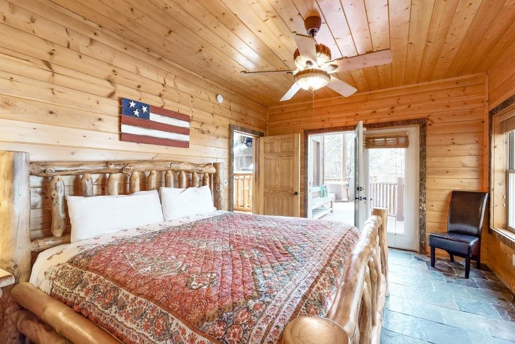 2556 Treehouse Lane Sevierville, TN 37876 - Photo 10 of 24 a bedroom with a large bed and a chandelier