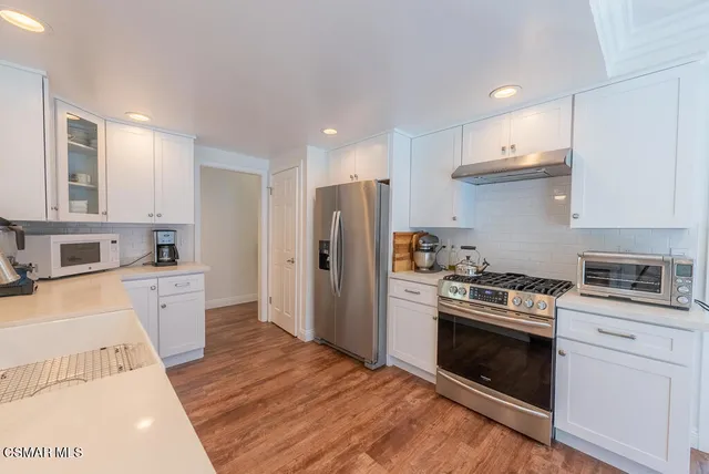 a kitchen with a white stove top oven and refrigerator