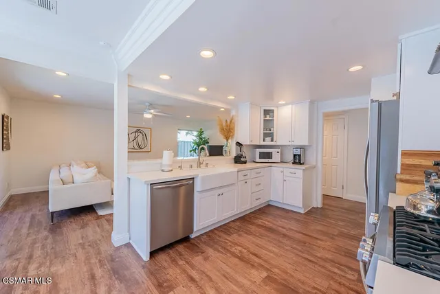 a large kitchen with kitchen island white cabinets and stainless steel appliances
