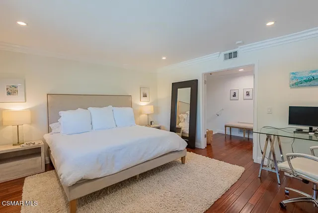 a bedroom with a bed and a flat screen tv on the dresser