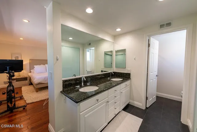 a spacious bathroom with a granite countertop sink a mirror and vanity