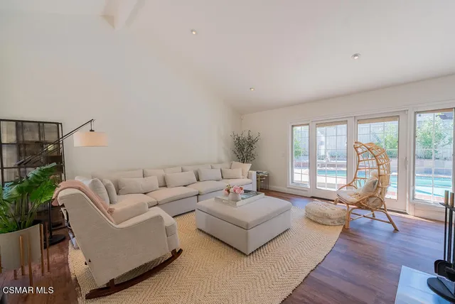 a living room with furniture and a large window with wooden floor