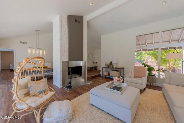 a living room with furniture a fireplace and a large window