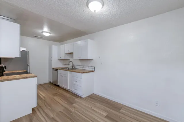 a kitchen with granite countertop a sink cabinets stainless steel appliances and a counter space
