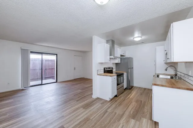 a kitchen with wooden floors and white appliances