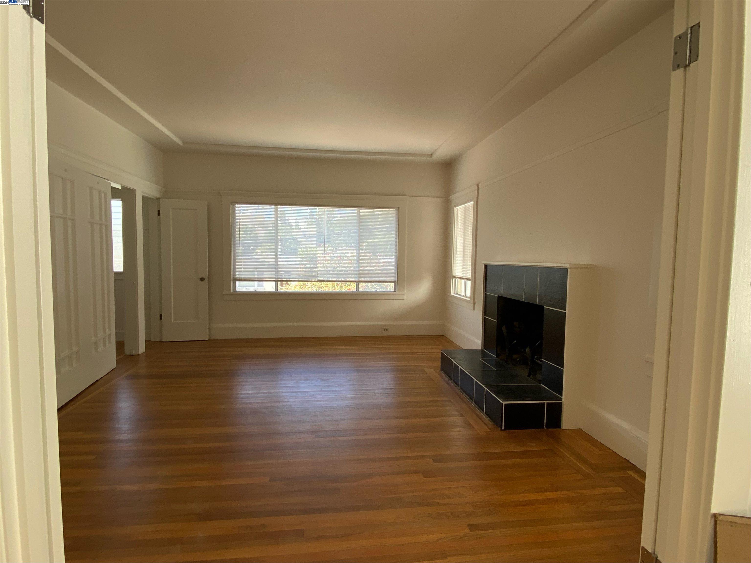 2418 Ashby Avenue, Unit # 2 Berkeley, CA 94705 - Photo 5 of 15 a view of empty room with wooden floor and fireplace
