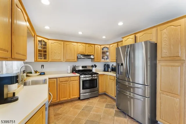 a kitchen with stainless steel appliances granite countertop a refrigerator stove top oven and sink