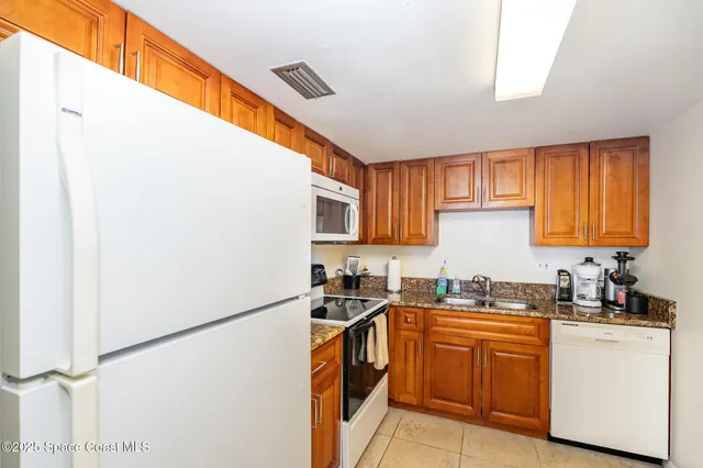 a kitchen with a refrigerator and a stove top oven