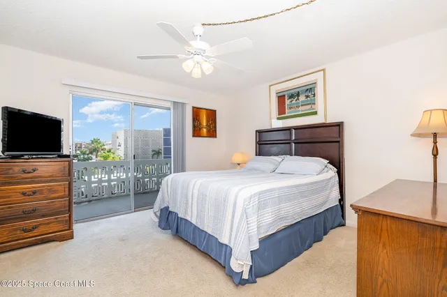 a bedroom with a large bed and a flat tv screen