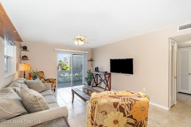 a living room with furniture a flat screen tv and a window