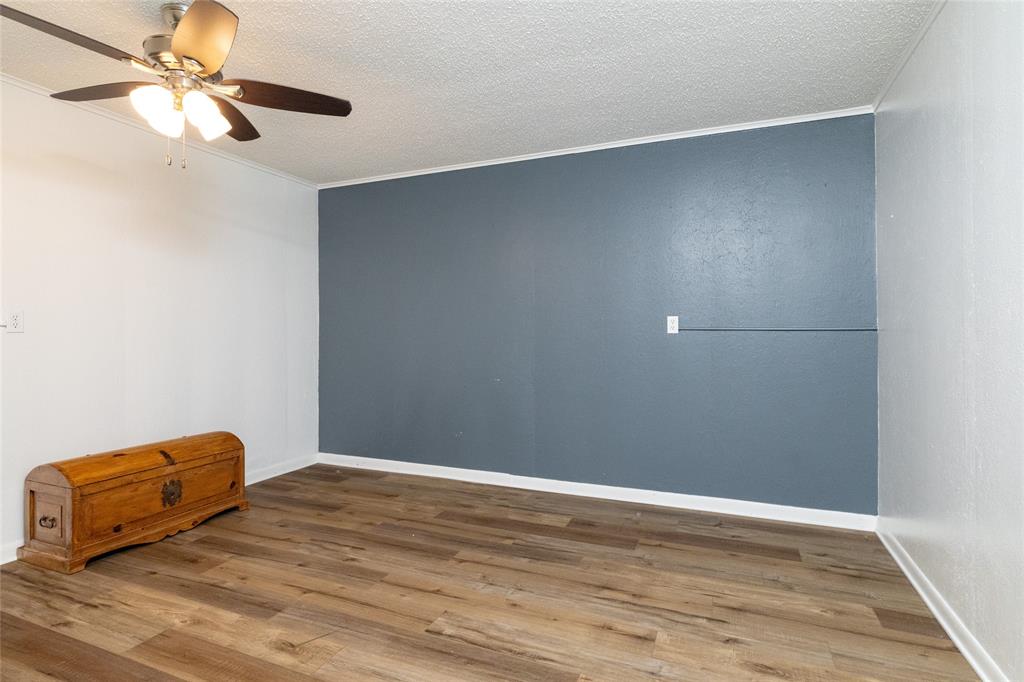 205 Timberlake Drive Azle, TX 76020 - Photo 29 of 40 an empty room with wooden floor and a ceiling fan