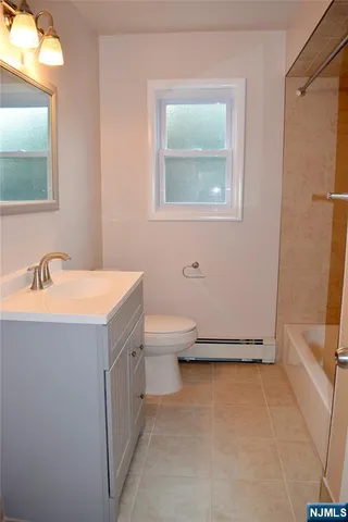 a view of a kitchen with a fridge and wooden floor