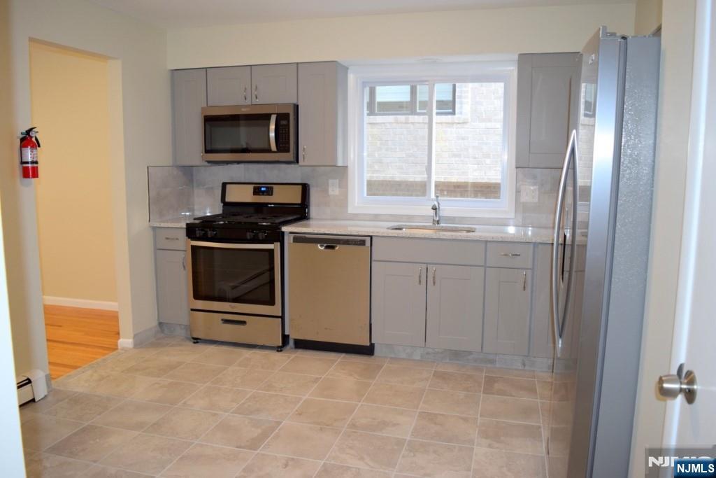 533 Roff Avenue Palisades Park, NJ 07650 - Photo 4 of 16 a kitchen with stainless steel appliances granite countertop a stove a sink and a refrigerator