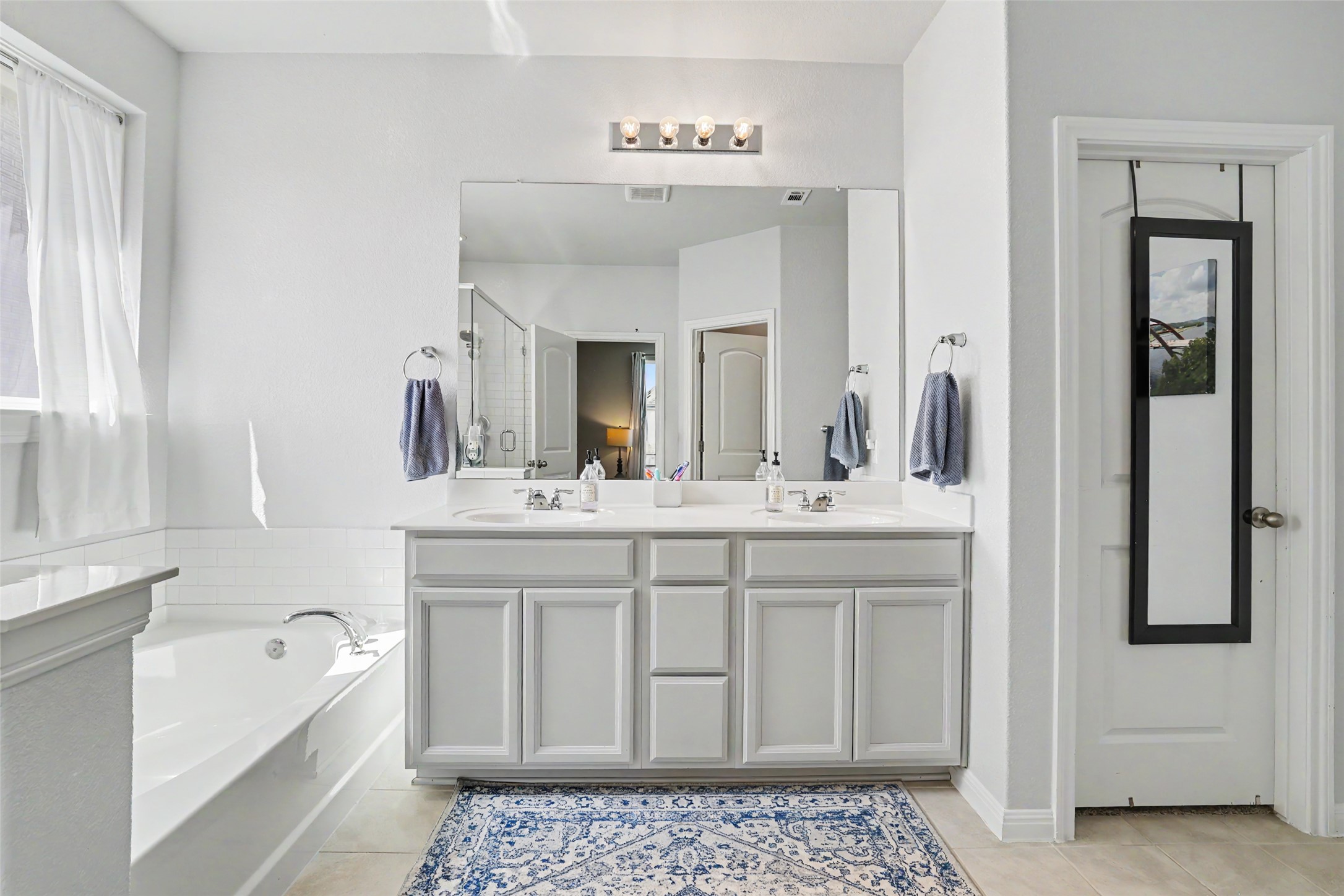 112 Rocking R Court Georgetown, TX 78633 - Photo 18 of 40 Double vanity sinks and a deep soaking tub create a functional, serene bathroom oasis.