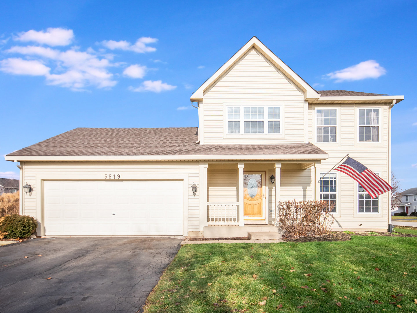 a view of a yard in front of a house with a large tree