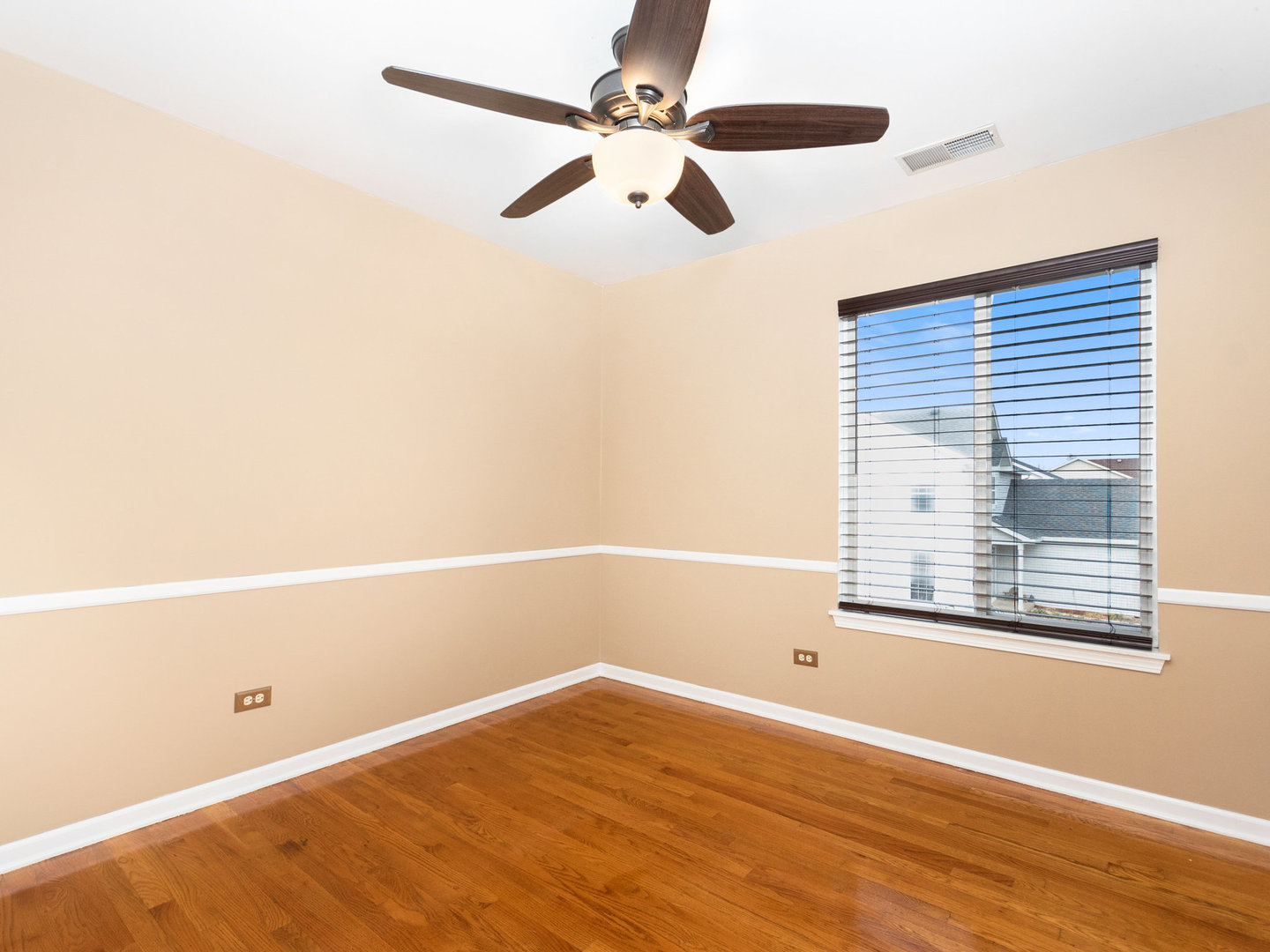 5519 Stonybrook Drive Plainfield, IL 60586 - Photo 14 of 27 an empty room with wooden floor fan and windows