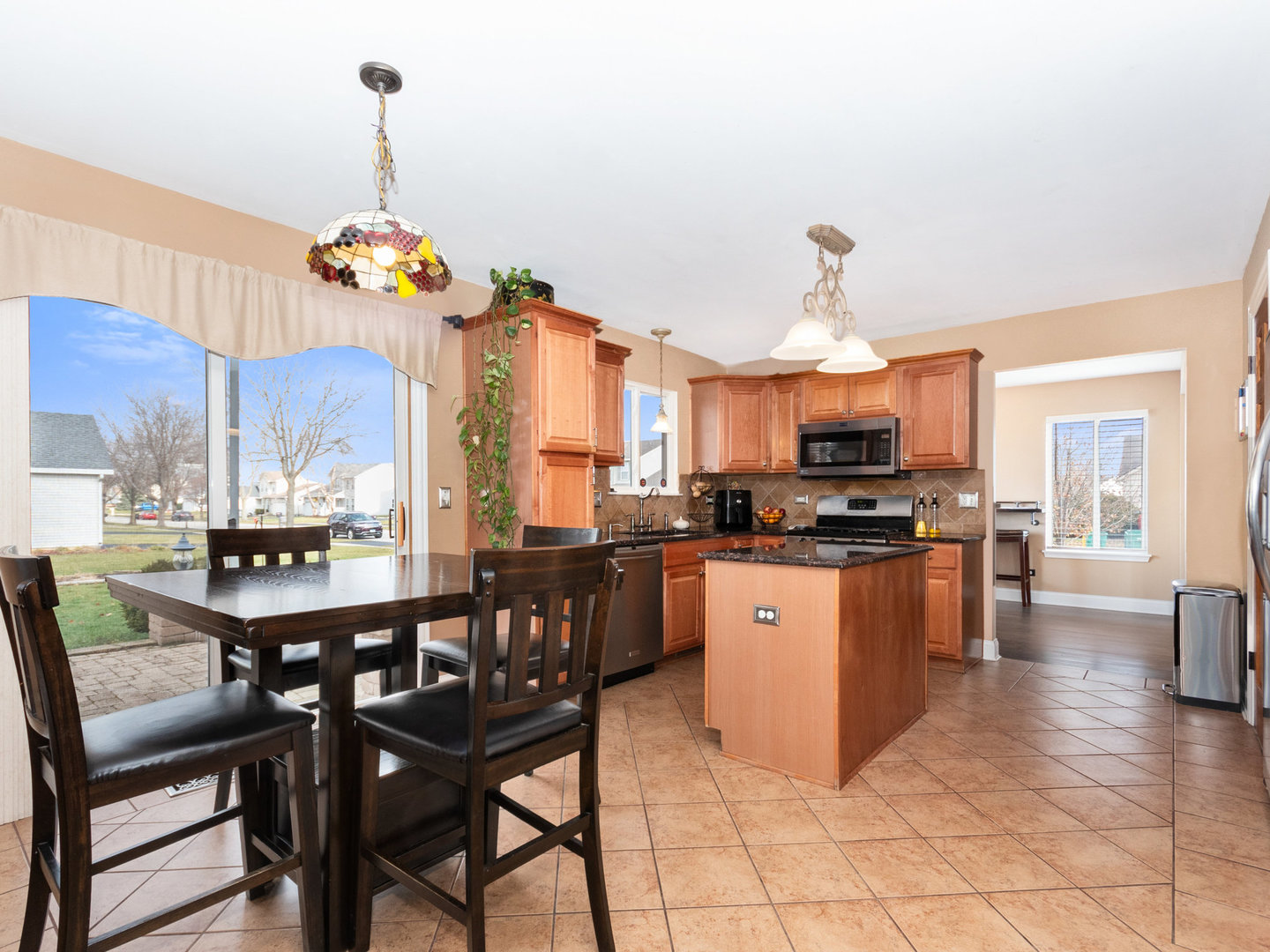 5519 Stonybrook Drive Plainfield, IL 60586 - Photo 8 of 27 a kitchen with stainless steel appliances kitchen island granite countertop a table chairs and a refrigerator