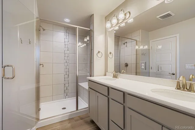 a bathroom with a shower sink and mirror