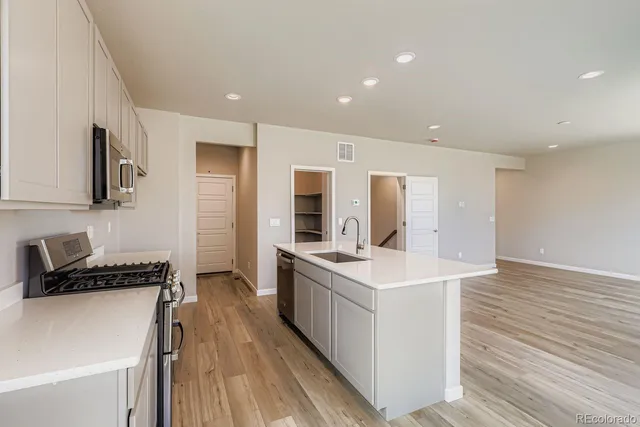 a kitchen with sink stove and refrigerator