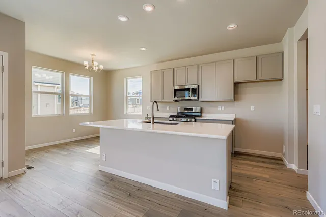 a kitchen with stainless steel appliances a microwave a sink a stove a refrigerator and cabinets