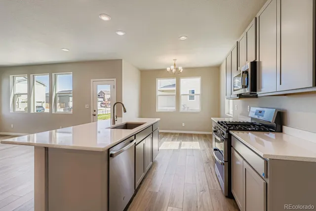 a kitchen with a sink stove and cabinets