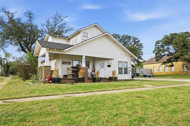 a view of a house with a big yard and large trees