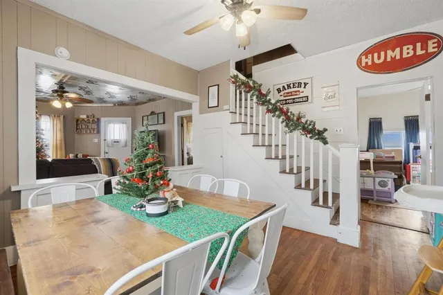 a view of a dining room and livingroom with furniture wooden floor a chandelier