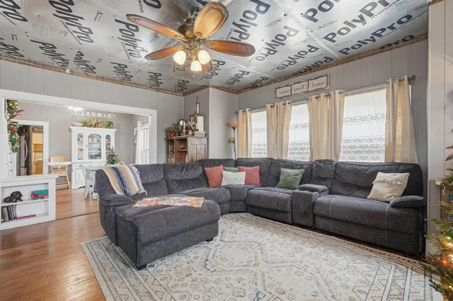a living room with furniture a wooden floor and a chandelier