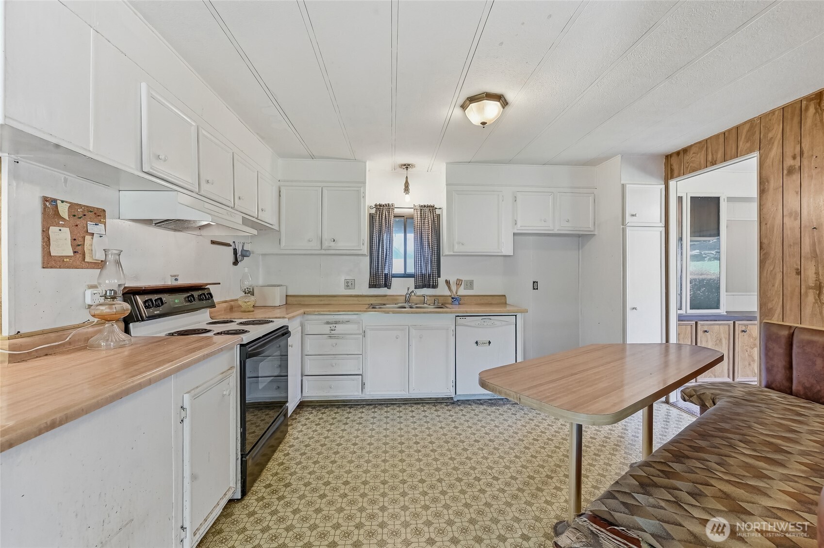32711 Commission Avenue Black Diamond, WA 98010 - Photo 13 of 34 a kitchen with a stove a sink dishwasher a dining table and chairs with wooden floor