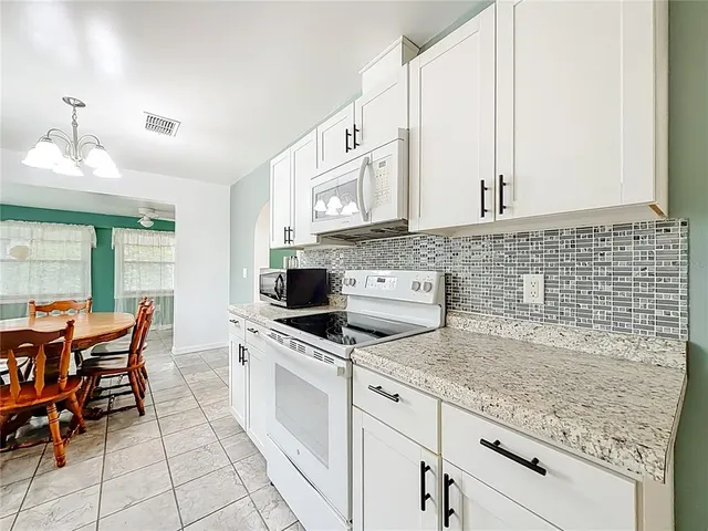 a kitchen with stainless steel appliances kitchen island granite countertop a sink and cabinets