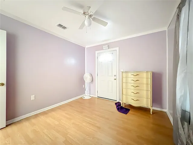 an empty room with windows and a ceiling fan