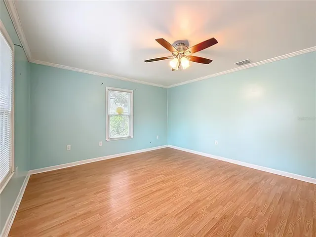a view of empty room with wooden floor