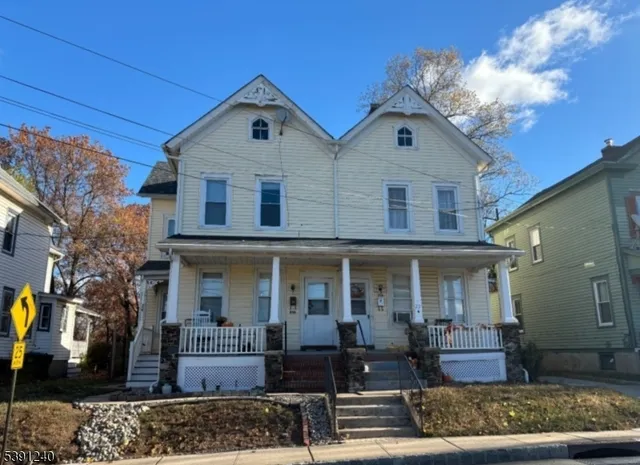 a front view of a house with garden and plants