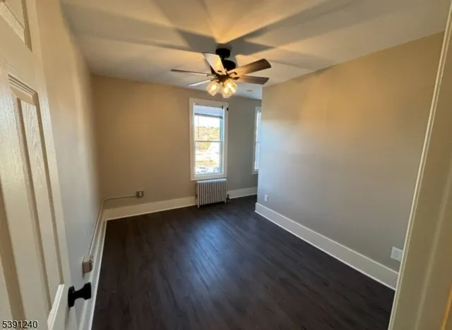 a view of a livingroom with a window and wooden floor