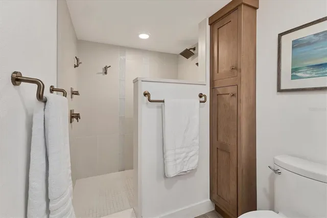 a bathroom with a double vanity sink toilet a shower and a mirror