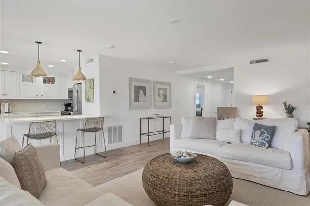 a kitchen with stainless steel appliances a dining table chairs and white cabinets next to a window