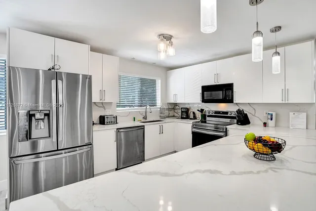a kitchen with a refrigerator sink and wooden cabinets