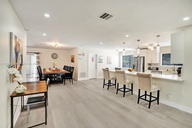 a kitchen with a dining table chairs and white cabinets