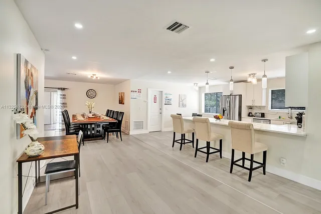 a large dining space with furniture and view of kitchen appliances